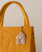 Yellow textured handbag with pearl acrylic 