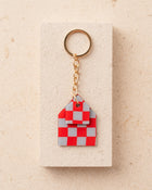 Red and gray checkered house-shaped keychain 